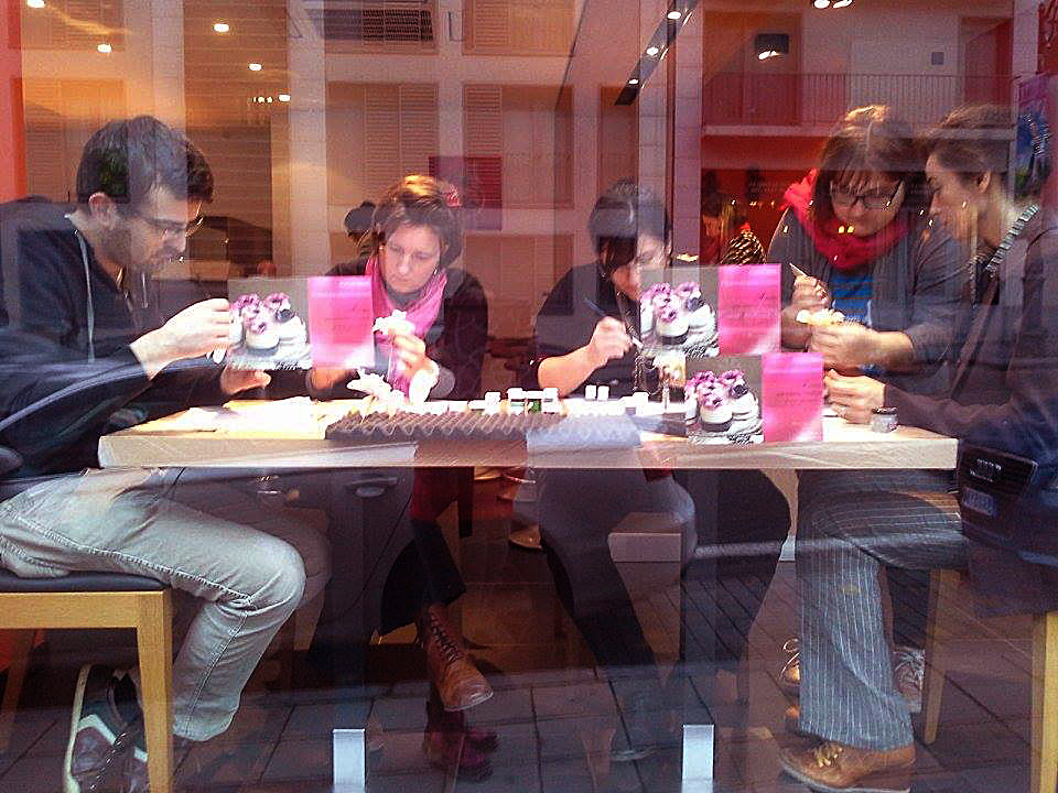 MIla is in the red scarf instructing students in sugar flower art.