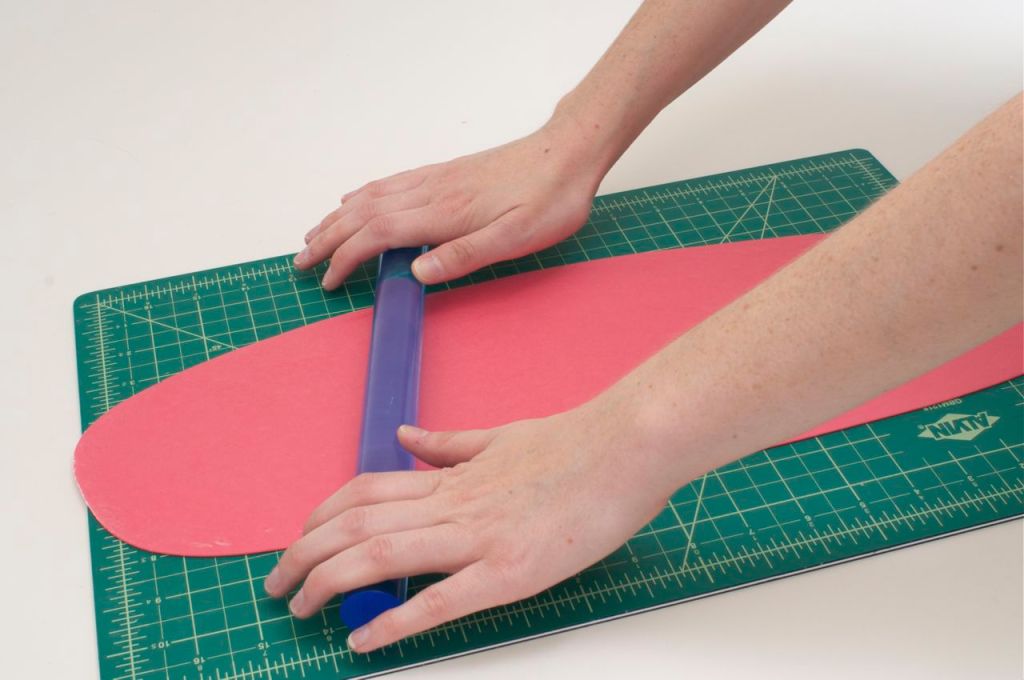 Roll out bright colored Satin Ice gum paste using a plastic rolling pin.