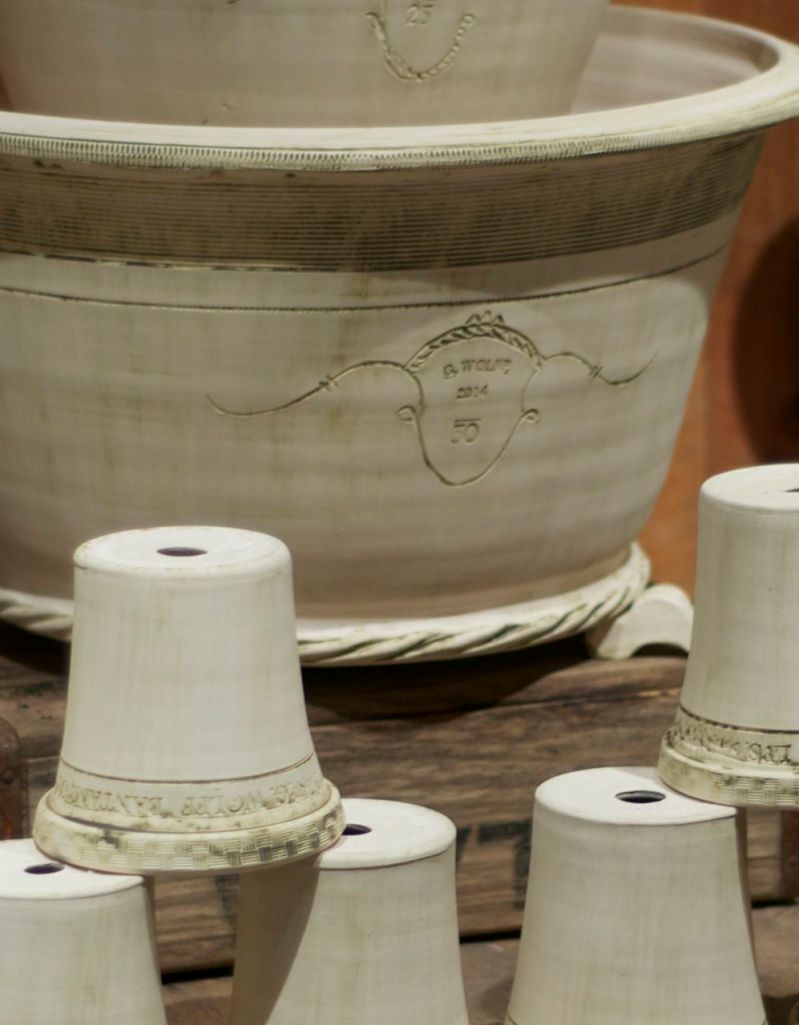 Guy has a very distinct way of signing his own work.  The stamp (or coggle) G. Wolff, the year and a number means the pot was made by his own hands on his own wheel.  There is also a signature on the bottom of the pot. The number on the pot is the weight.